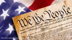 top of declaration of independence at an angle sitting on top of american flag