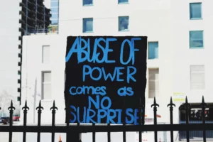 protest sign: abuse of power comes as no surprise